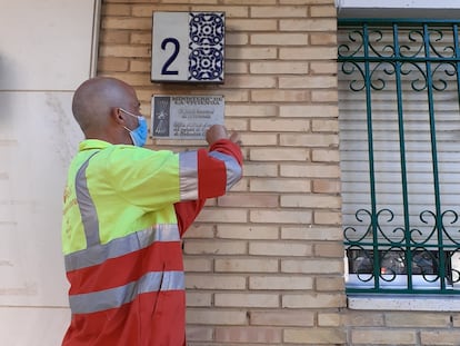 Un operario del Ayuntamiento de Sevilla retira una placa del Ministerio de Trabajo de Franco.