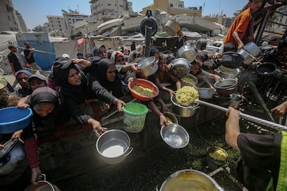 Mujeres palestinas aguardaban ayer para recibir comida de una cocina comunitaria en Gaza.