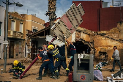 Recostrución y solicitud de ayudas a los vecinos de Alfafar afectados por la DANA. Un grupo de bomberos trabajan para retirar una señal urbana que ha sido afectada por los efectos de la riada en Alfafar.