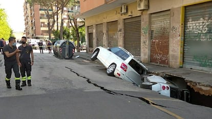 Dos coches atrapados en un enorme socavón en el barrio romano de Torpignattara, el pasado martes.
