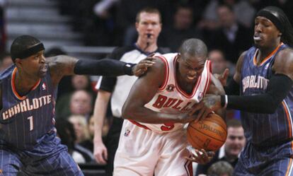 Stephen Jackson, a la izquierda, and Gerald Wallace, a la derecha, de los Bobcats presionan a Luol Deng, de los Bulls de Chicago, durante el partido que ganaron los de Charlotte por 82-83.