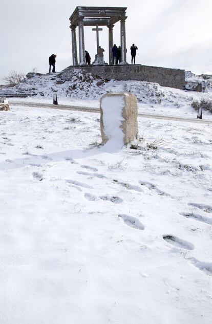 Un grupo de turistas toma fotografías los Cuatro Postes, en Ávila, tras la nevada caída en la capital abulense.
