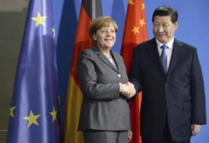 El presidente chino, Xi Jinping (i), y la canciller alemania, Angela Merkel (d), estrechan sus manos tras la rueda de prensa que ofrecieron en la sede de la Cancillería en Berlín, Alemania, hoy, viernes 28 de marzo de 2014.