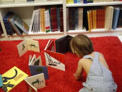 Un niño juega con libros infantiles en una librería.