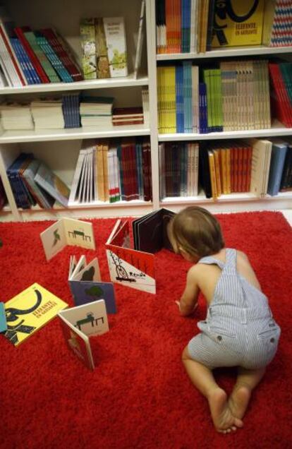 Un niño juega con libros infantiles en una librería.