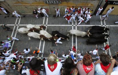 Varios espectadores ven a los corredores en la calle Estafeta en la terecera jornada de los encierros.