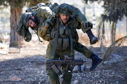 Un soldado israelí carga a un compañero durante un entrenamiento cerca de la frontera con Líbano, este miércoles en Israel.  