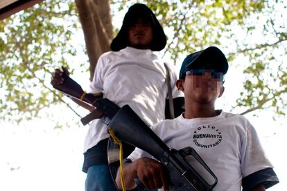 Dos adolescentes que forman parte de la autodefensa de La Ruana, con sus armas.