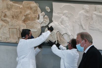 Los conservadores del Museo del Acrópolis, en Atenas, colocan un fragmento del friso del Partenón, dejado en depósito en enero de 2022 por el Museo Salinas de Palermo, que lo exponía desde el siglo XIX.