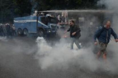 Policías antidisturbios utilizan un cañón de agua para dispersar a los manifestantes durante una protesta contra las políticas del Banco Central Europeo (BCE) en Nápoles (Italia) hoy.