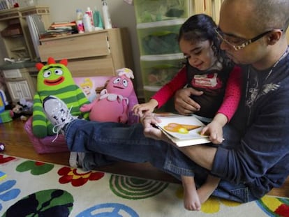 Christopher Astacio lee con su hija, Cristina de dos a&ntilde;os, diagnosticada de autismo.  