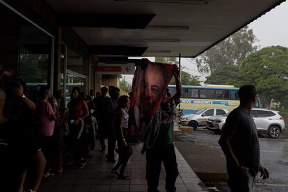 Uno de los integrantes de la caravana levanta una bandera con la imagen de Lula da Silva, en una caseta de descanso en la carretera a Brasilia.