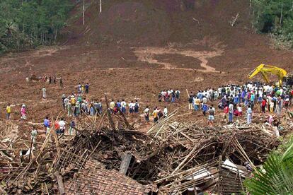 Equipos de rescate y gentes del lugar, en la zona afectada por el deslizamiento de tierras.