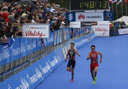 Javier Gomez of Spain, right, races Jonathan Brownlee of Britain to the finish line to win the race and world series championship in the elite men race during the World Triathlon Grand Final in Hyde Park, London, Sunday, Sept. 15, 2013. (AP Photo/Sang Tan)