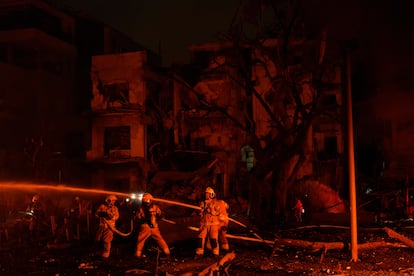 Los bomberos trabajan para extinguir un incendio después de que un misil lanzado desde Irán impactara Tel Aviv, este lunes.