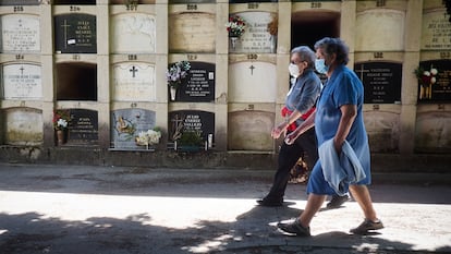 Two seniors wearing masks make a visit to a cemetery in Pamplona, northern Spain.