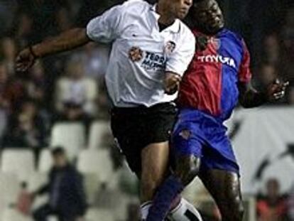 El valencianista Carew (izda.) salta con el jugador del Basilea Atouba.