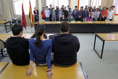 Profesores y alumnos leen un manifiesto en apoyo a los detenidos (de espaldas) en Políticas.