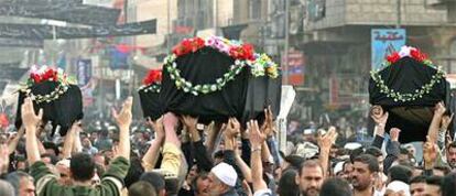 Los féretros de cuatro víctimas del atentado del martes en Bagdad son portados por la multitud durante los funerales celebrados ayer en la capital iraquí.