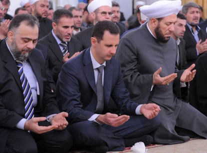 El presidente El Asad reza junto al gran muftí sirio (derecha).