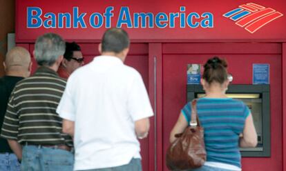Clientes de Bank of America hacen cola en un cajero para sacar dinero.