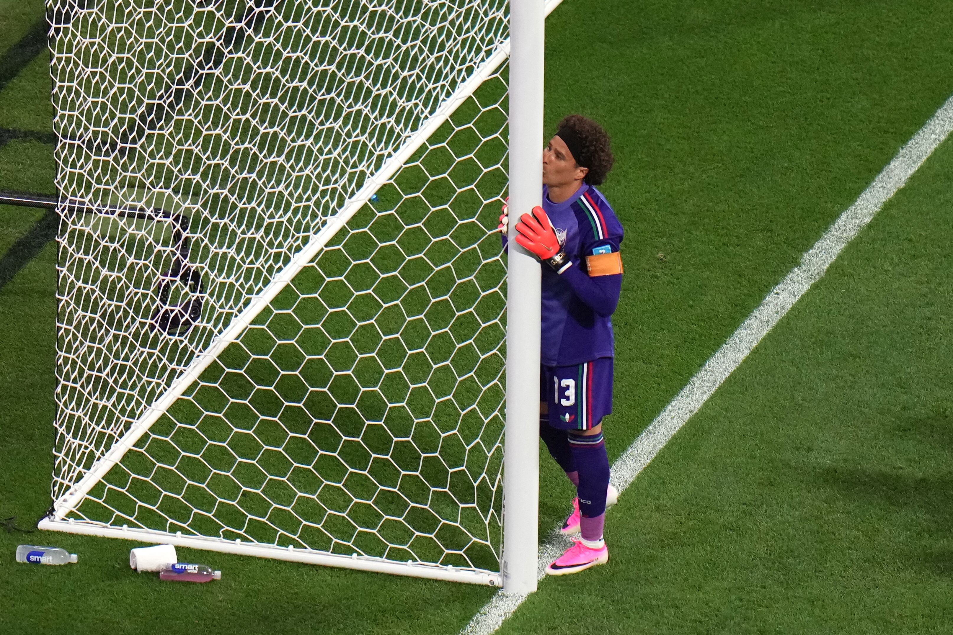 Ochoa besa uno de los palos de la portería tras ingresar al campo del Azteca.
