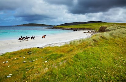 Cuatro jinetes cabalgan por la playa de Selerna, en la localidad irlandesa de Cleggan, en verano.