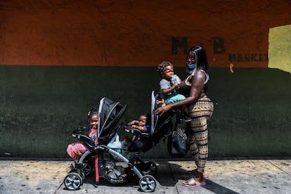 Una mujer posa junto a sus tres hijos en un barrio afroamericano de Miami (EE UU).