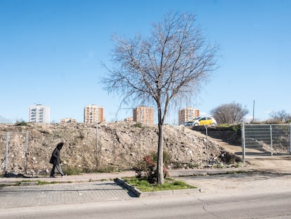 Una mujer pasa delante del descampado vallado donde se encontraba el poblado chabolista San Dalmacio, donde se prostituían las menores tuteladas de la Comunidad de Madrid.