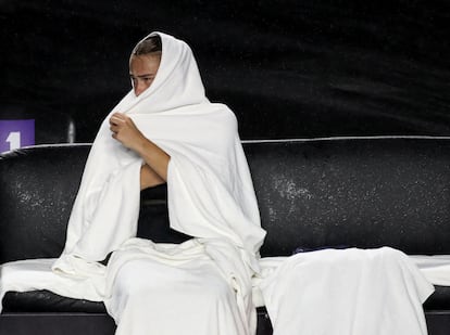 Sabalenka se protege de la lluvia con toallas durante la semifinal contra Swiatek.