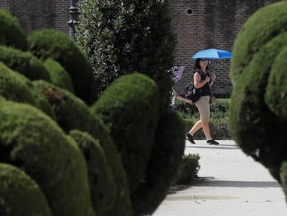 Una turista se protege del sol en El Retiro.