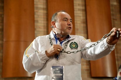 El sargento Cesar Lasso agita unas cadenas y se las cuelga al cuello durante la audiencia de reconocimiento de las FARC-EP, caso 01.