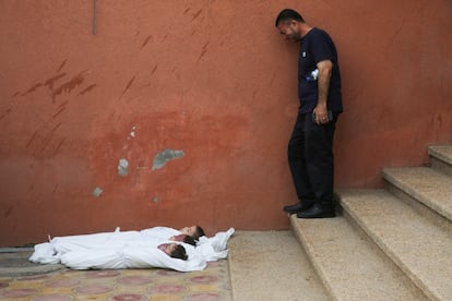 Un hombre llora ante los cadáveres de tres niños muertos en un ataque israelí en el hospital Nasser de Jan Yunis, este jueves.