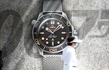 A woman walks past a poster advertising a Seamaster Professional Co-Axial Master Chronometer  "007 No Time To Die" special edition watch of Swiss manufacturer Omega at the Bahnhofstrasse shopping street in Zurich, Switzerland August 12, 2020.   REUTERS/Arnd Wiegmann