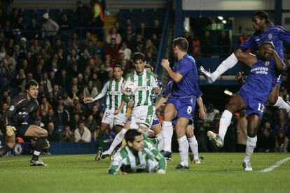 Drogba (a la derecha, saltando) despeja con contundencia un balón en su área.