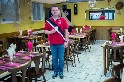 Jean-Loup Tiesset, 54, poses with his voting card on February 9, 2017 in his cafe-restaurant in Calais, near the former migrant camp nicknamed "The Jungle" in Northern France.
What should be the priorities of the next French president?
"My first wish would be that the next president harnesses the services of the state to change the taxes on businesses, especially our social security charges. As for the migrant crisis -- which caused a lot of human, social and financial difficulties for Calais residents \x96- the president should get in contact with neighbouring countries to ensure that the people of Calais no longer find themselves in the situation they have been in for the past 10 years. It's not right that British immigration checks take place on our soil. It's up to England to welcome migrants and manage the migrant flow that the country attracts." / AFP PHOTO / PHILIPPE HUGUEN / RESTRICTED TO EDITORIAL USE - RESTRICTED TO FRENCH ELECTIONS ILLUSTRATION PURPOSE