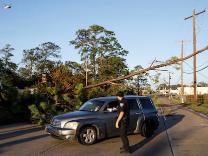 A police officer talks with a couple in a car after Hurricane Delta, in Jennings, Louisiana, U.S., October 10, 2020