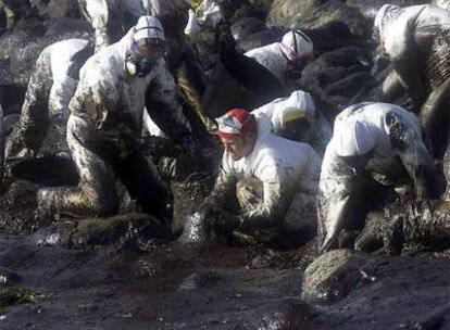 Voluntarios limpian de chapapote una playa de Lira, en Carnota, en diciembre de 2002.