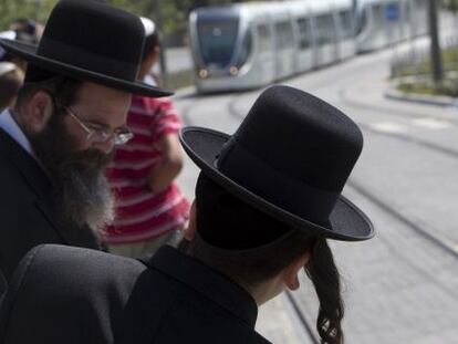 Pasajeros jud&iacute;os esperan el tranv&iacute;a en Jerusal&eacute;n en agosto. 