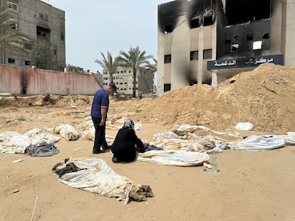 Una mujer y un hombre observan uno de los cuerpos recuperados de la fosa común del hospital Al Nasser, en Jan Yunis, este viernes.