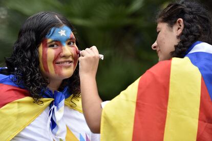 Una chica se punta la cara con los colores de la bandera catalana durante la celebración de la Diada, en Barcelona.