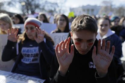 En la plaza frente a la Casa Blanca se manifestaban centenares de estudiantes a los gritos de "¡Nunca más!" y "¡Basta!". En la imagen, dos jóvenes levantan las manos donde se han escrito "No disparar", frente a la Casa Blanca en Washington, el 14 de marzo de 2018.