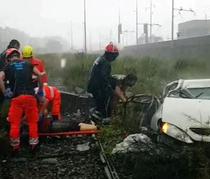 Varios miembros de los equipos de rescate atienden a una de las víctimas tras desplomarse un viaducto sobre la autopista A10 en Génova (Italia).