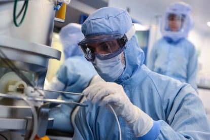 Un empleado con un traje de riesgo biológico toma una lectura de temperatura en el laboratorio BioNTech en Marburg (Alemania).