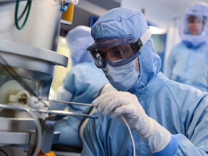 Un empleado con un traje de riesgo biológico toma una lectura de temperatura en el laboratorio BioNTech en Marburg (Alemania).