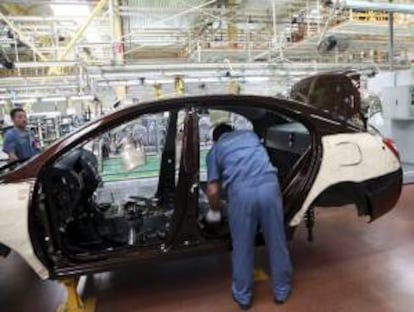 Varias personas trabajan en una línea de ensamblaje de la planta de fabricación de automóviles Geely en Ningbo, provincia de Zhejiang (China). EFE/Archivo