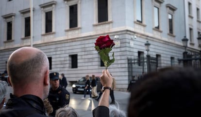 Una persona sujeta una rosa roja durante la llegada del féretro de Alfredo Pérez Rubalcaba, este viernes en el Congreso.