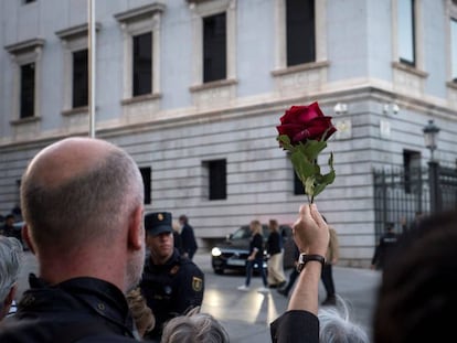 Una persona sujeta una rosa roja durante la llegada del féretro de Alfredo Pérez Rubalcaba, este viernes en el Congreso.