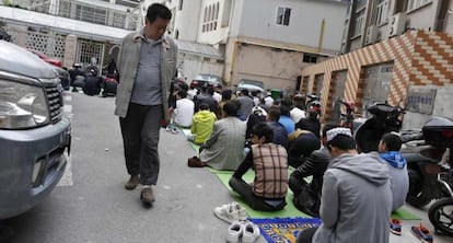 Un hombre observa a un grupo de la etnia uigur durante el rezo.  