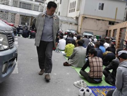 Un hombre observa a un grupo de la etnia uigur durante el rezo.  